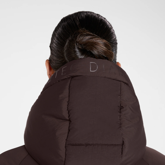 Aztec Diamond Matte Long Puffer AW26 Variant Espresso. Back view of a person wearing a dark brown puffer jacket with a high padded collar, shown against a light gray studio background.