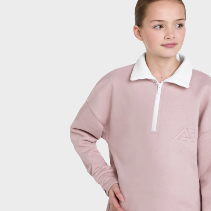Person wearing a pink sweater with a white collar on a light grey background
