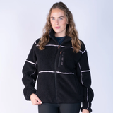 Blackfort AW26 Layla Fleece Variant Black & Blush. Black fleece with Blush line detailing and rose gold zips against a grey background. 