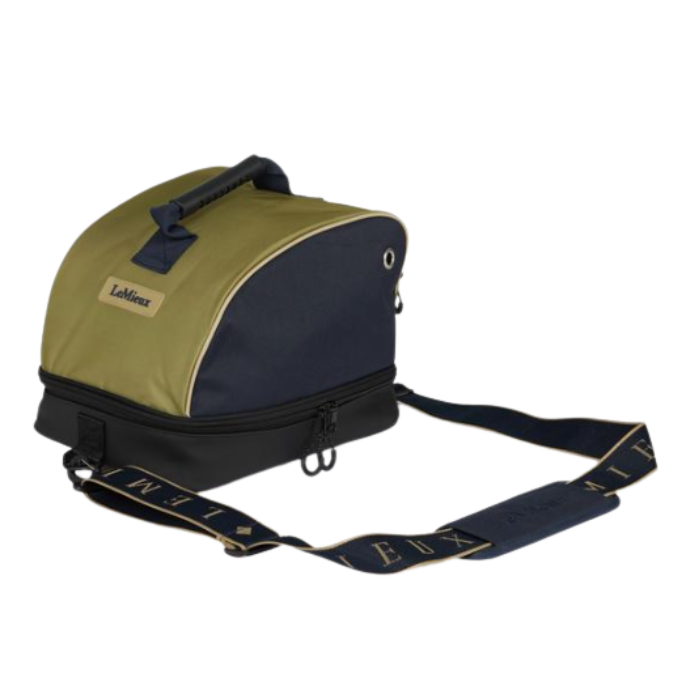 LeMieux AW26 Hat Bag Varient Gooseberry. A LeMieux saddlebag-style bag in olive green and navy blue, featuring a top handle, zippered compartments, and a wide navy shoulder strap with gold lettering, shown on a plain white background.