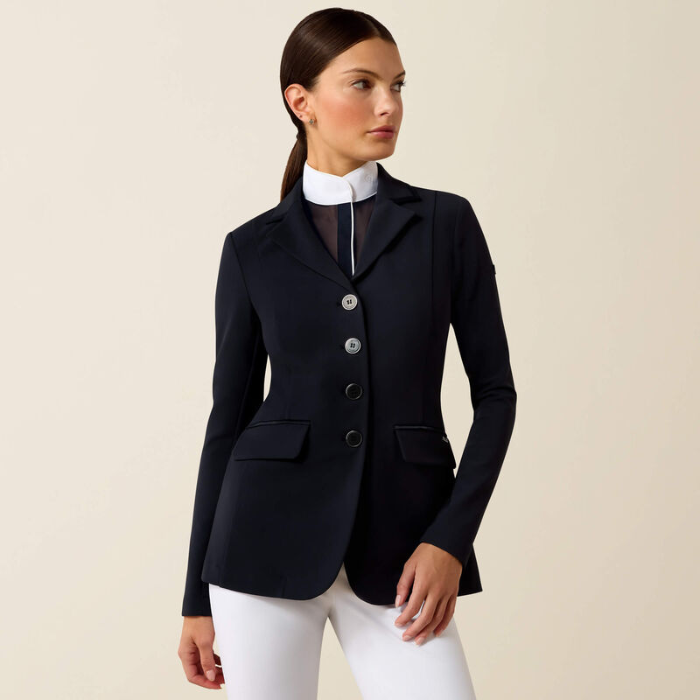 Woman wearing a navy blazer over a white shirt and pants on a beige background