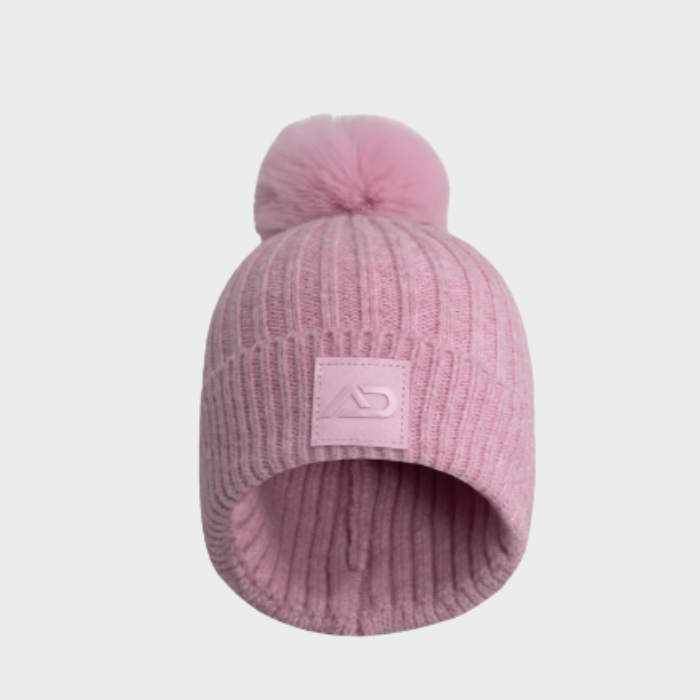 Pink knit beanie with logo and a pom-pom on a light grey background