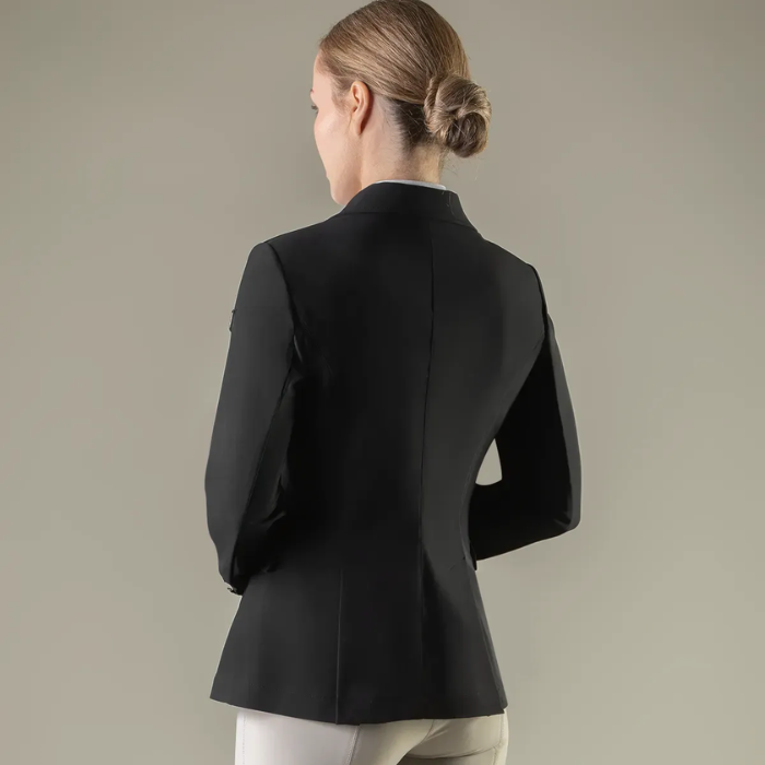 Person wearing a black blazer against a plain background