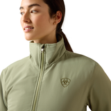 Ariat Women's Stable 2.0 Insulated Jacket Varient Oil Green. Woman wearing a olive bomber coat a with a high neck on a white background.