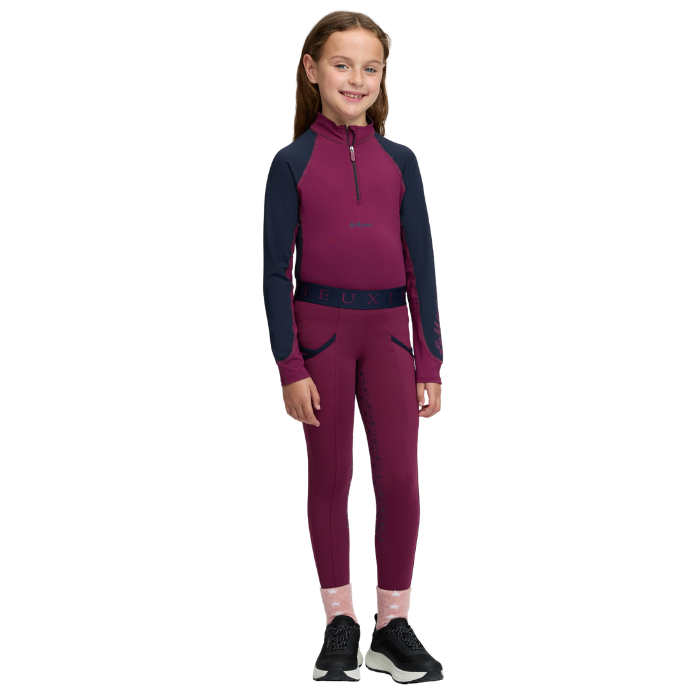 LeMieux AW26 Mini Base Layer Varient Blackberry. A young girl modeling a two-piece athletic two piece in a deep magenta and navy blue colorway, featuring a long-sleeve quarter-zip top and matching leggings, set against a plain white background.