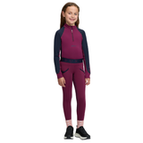 LeMieux AW26 Mini Base Layer Varient Blackberry. A young girl modeling a two-piece athletic two piece in a deep magenta and navy blue colorway, featuring a long-sleeve quarter-zip top and matching leggings, set against a plain white background.