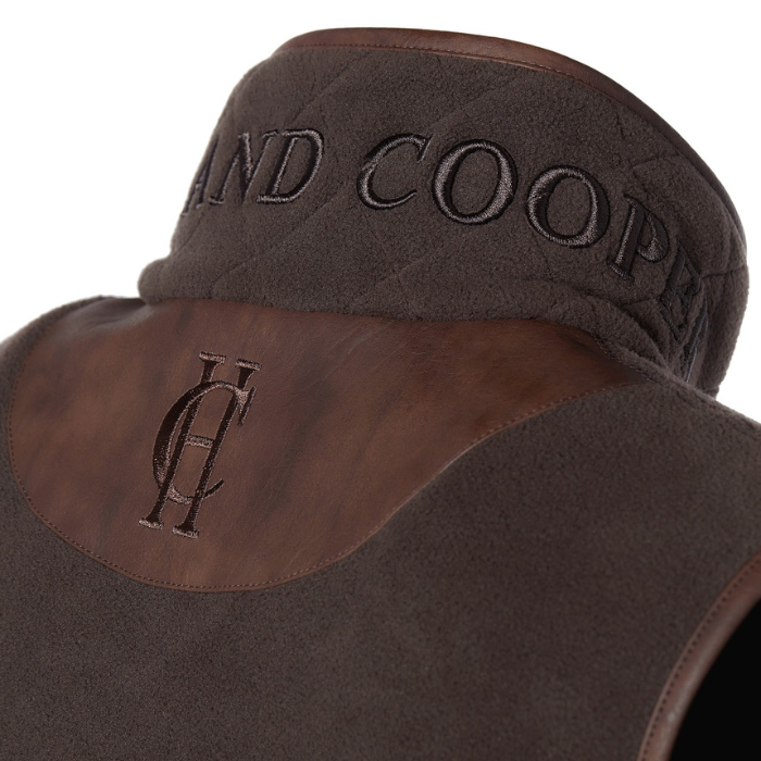 Holland Cooper Country Fleece Gilet Variant Chocolate. Close-up of a brown gilet with embossed leather panels and embroidered branding.