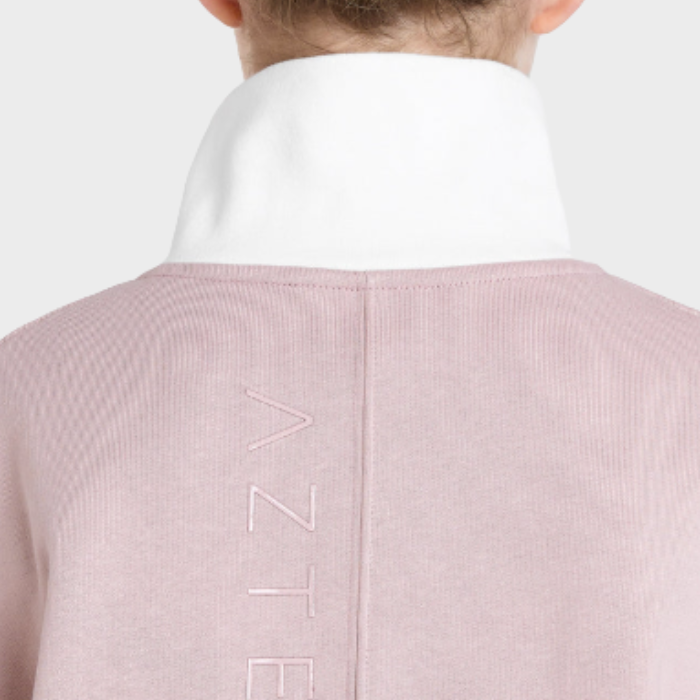 Back of person wearing a pink jumper with a brand logo on a white background