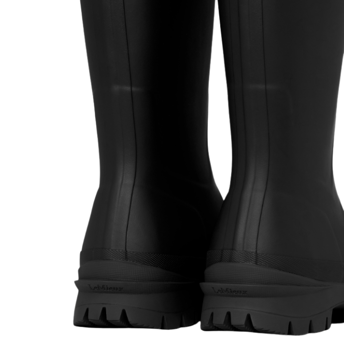 LeMieux AW26 Mens Bramshaw Welly Varient Black. Close-up rear view of a pair of black rubber rain boots with textured soles, showing the brand name 'LeMieux' embossed on the heel.