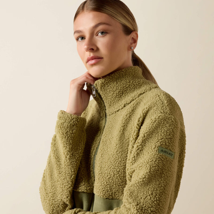 Ariat Ladies Laviolette Full Zip Jacket Variant Oil Green. A woman wearing a textured olive green fleece zip-up jacket, photographed against a plain light beige studio background.