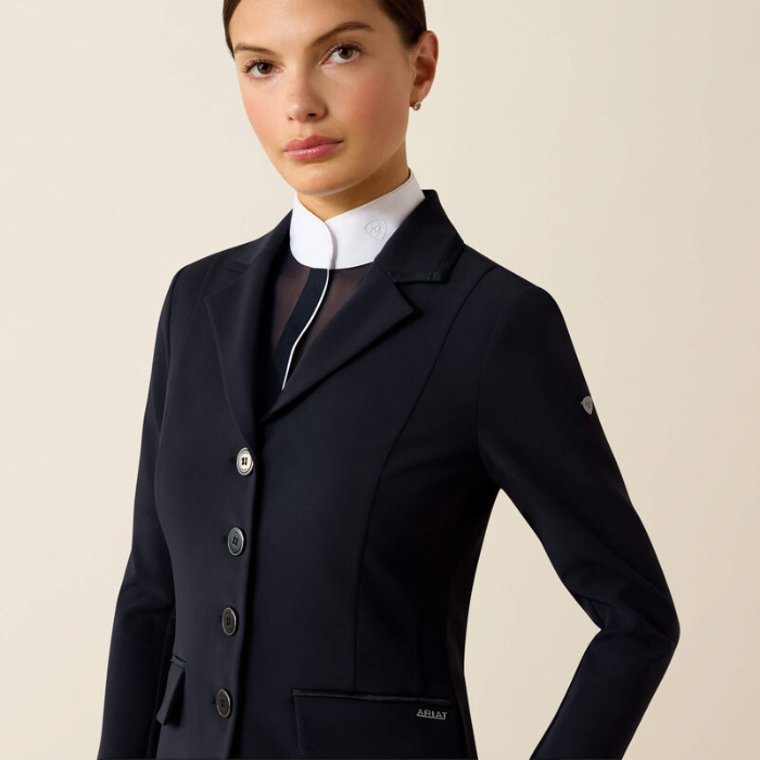 Woman wearing black blazer and white shirt on beige background