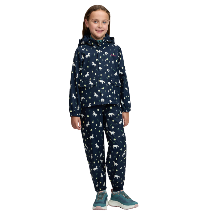 LeMieux AW26 Mini Pippin Splash Jacket Varient Navy. A young girl stands against a white background wearing a matching hooded jacket and jogger pants set in navy blue with a white animal print, paired with teal sneakers.