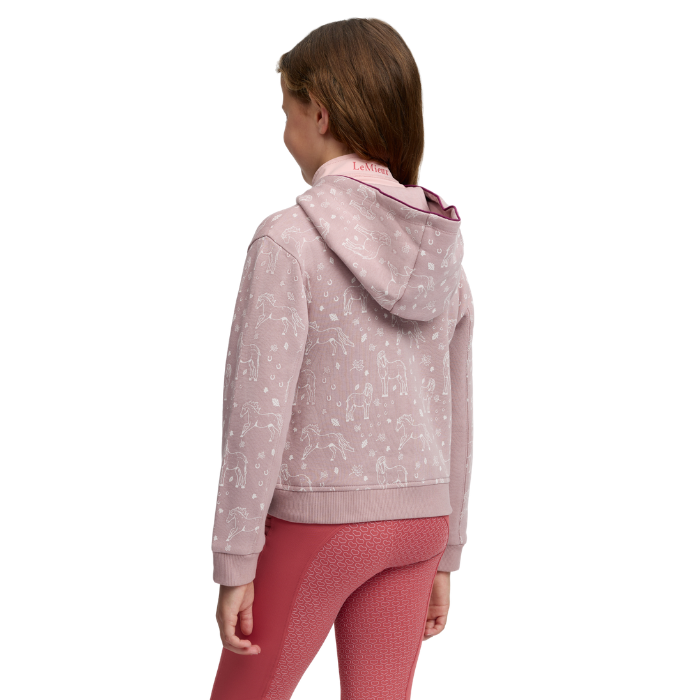 LeMieux AW26 Mini Charlie Hoodie Varient Wild Rose. A child model shown from the back wearing a light pink hooded sweatshirt with a white allover pattern and pink leggings, against a plain white background.