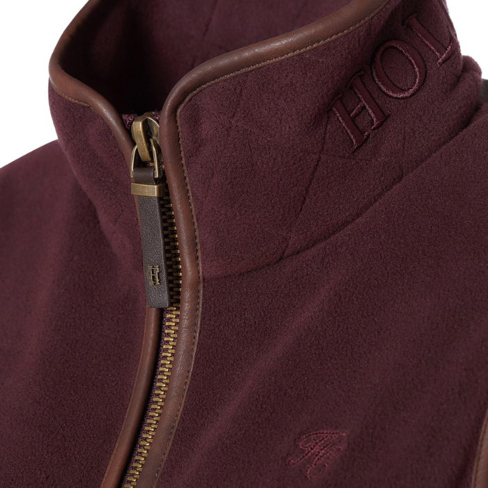 Holland Cooper Country Fleece Gilet Variant Mulberry. Close up of a mulberry collar with Holland Cooper branding and brown detailing.