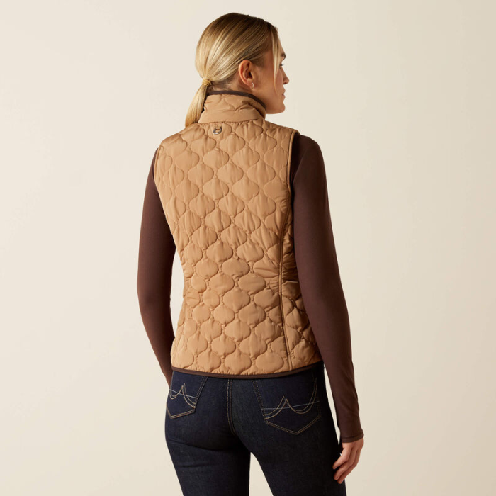 Woman wearing a quilted beige vest on a beige background