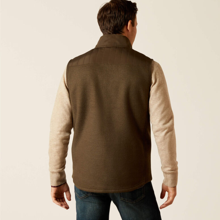 Man wearing a brown gilet over a beige shirt on a beige background