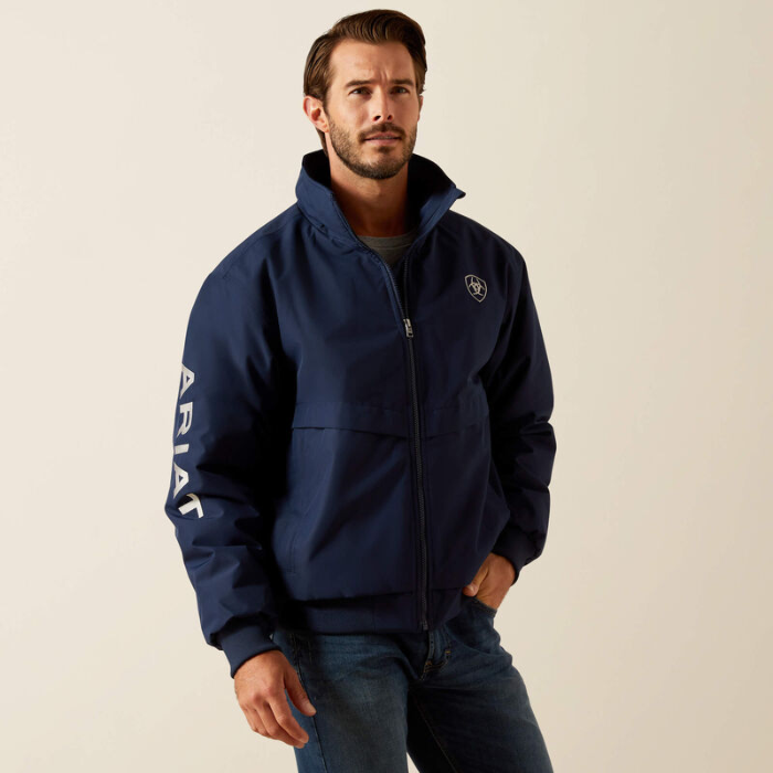 Man wearing a navy blue Ariat jacket on a beige background