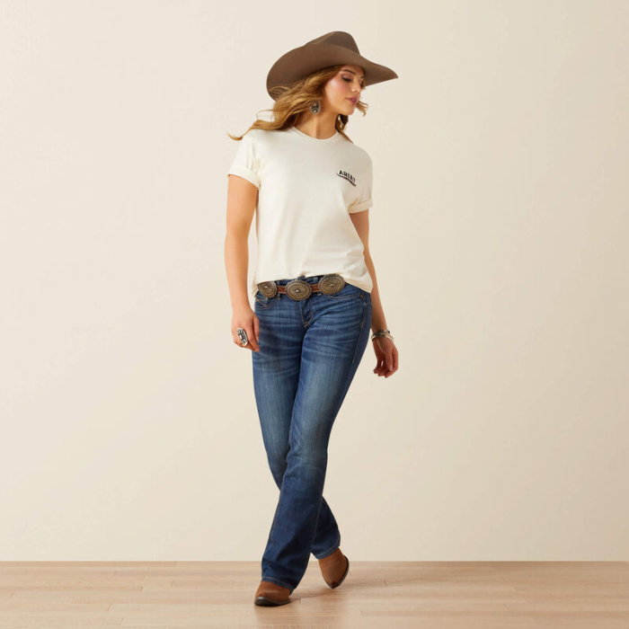 Woman wearing a light t-shirt, blue jeans, and a brown cowboy hat on a beige background