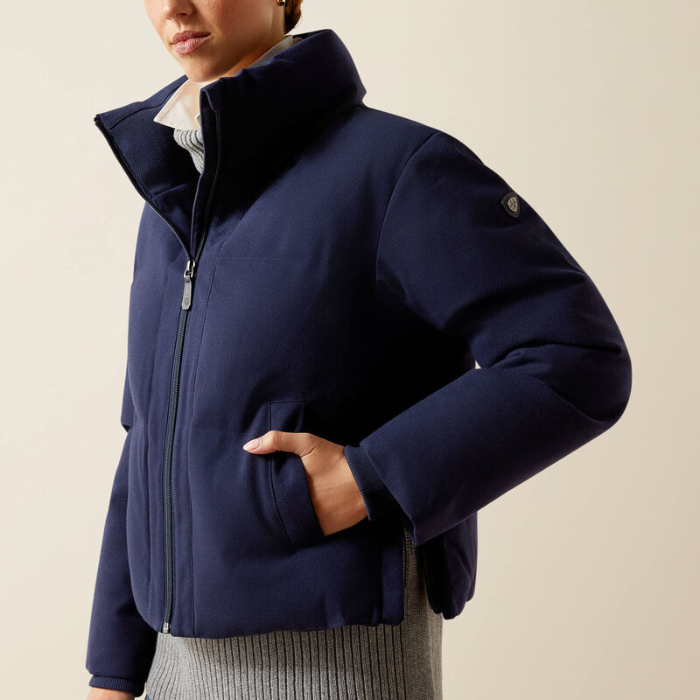 Person wearing a navy blue jacket on a beige background