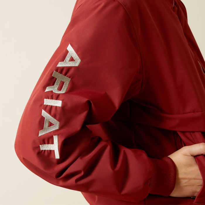 Brown jacket with 'Ariat' branding on a beige background