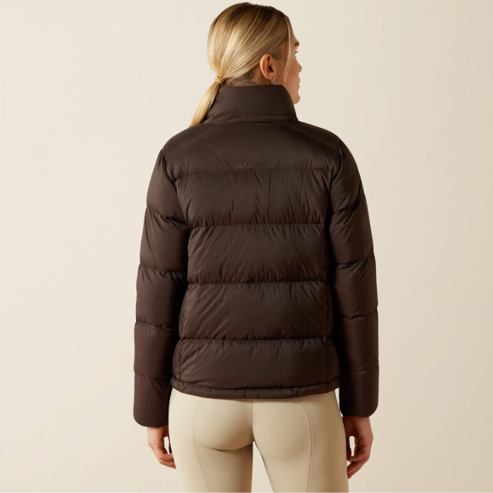 Person wearing a brown puffer jacket on a beige background