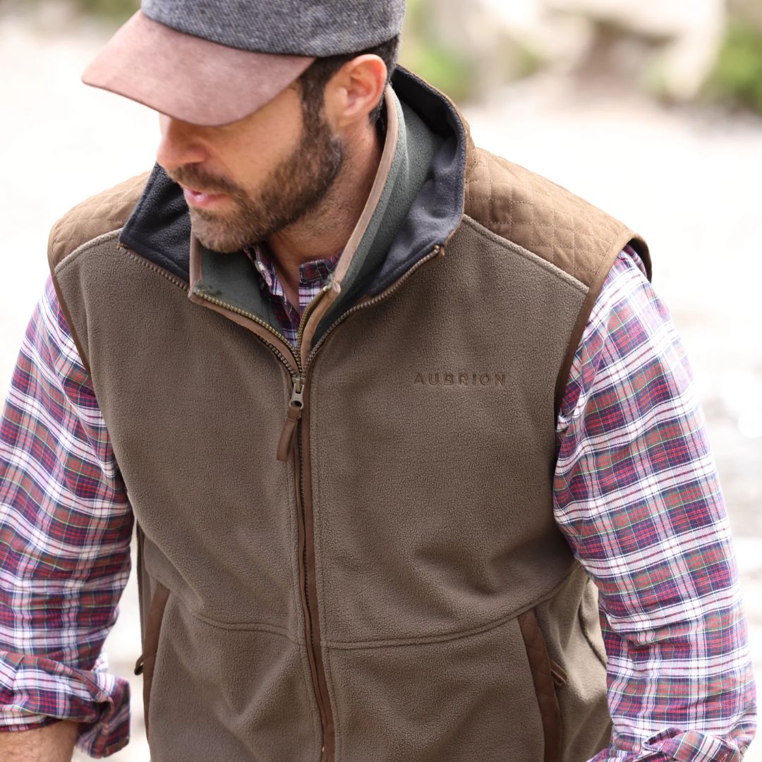 Man wearing a brown gilet with 'Aubrion' logo outdoors