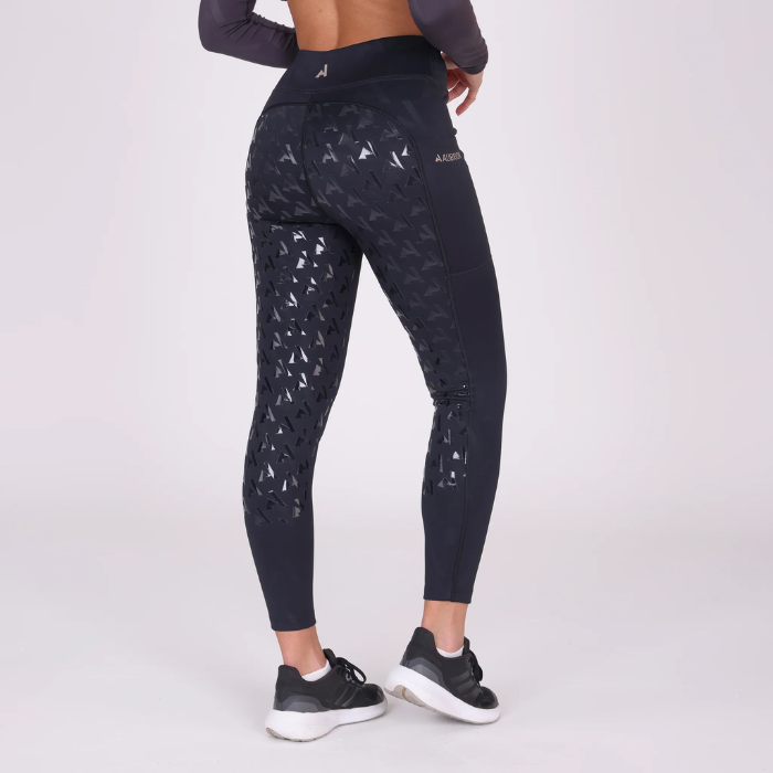Person wearing black riding leggings with silicone grip surface