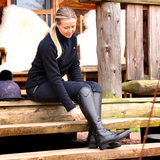 Person wearing black riding outfit sat on wooden steps