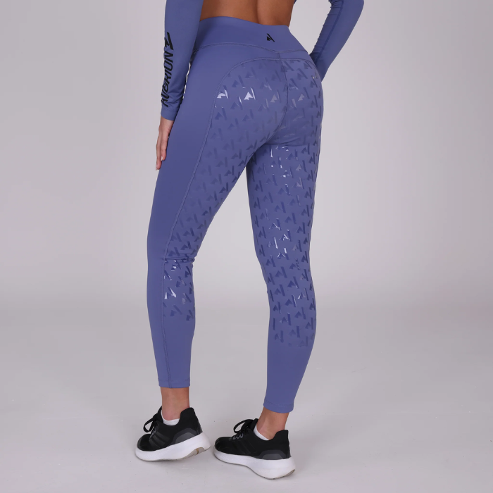 Person wearing blue riding leggings with silicone grip surface