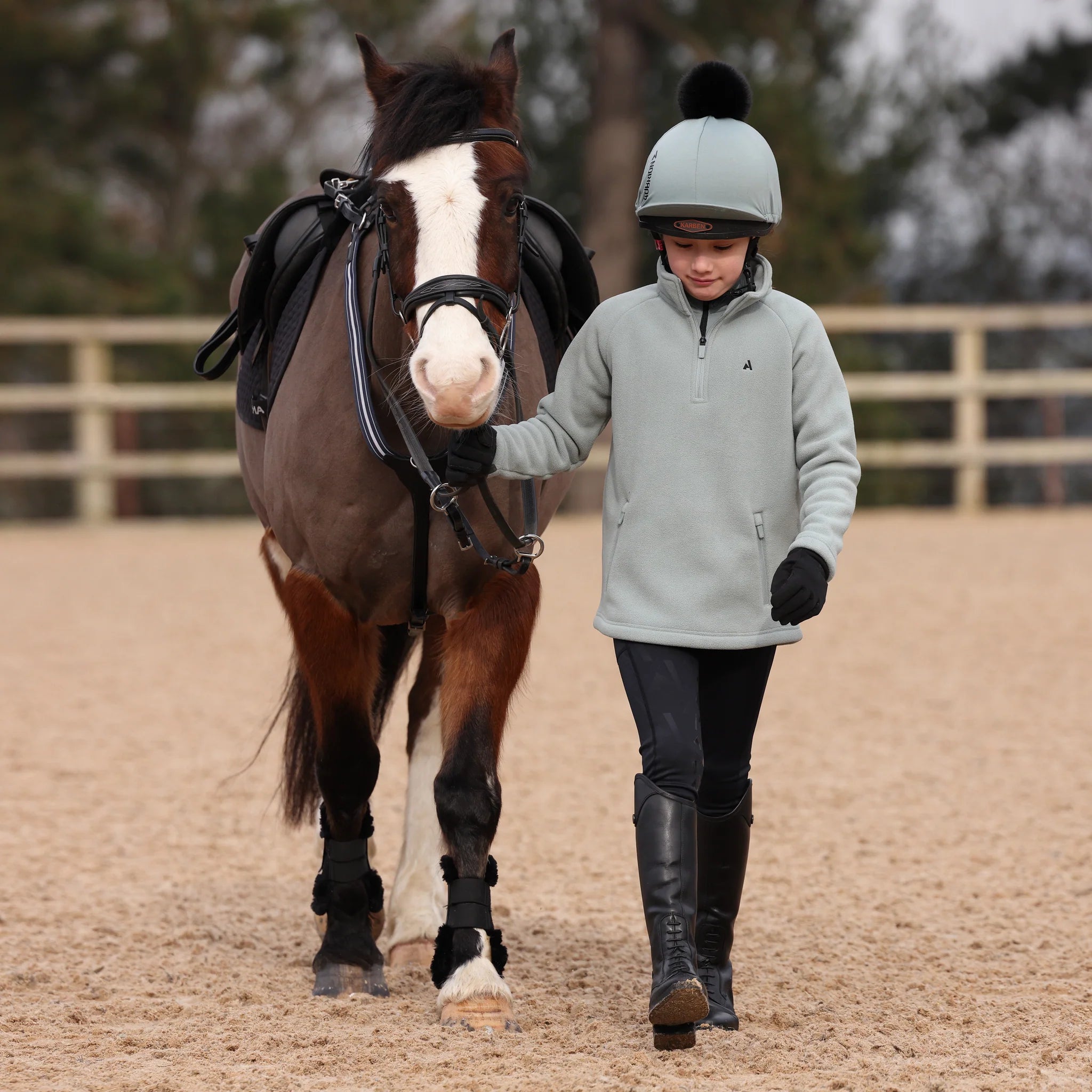 Person walking a horse in an outdoor equestrian setting