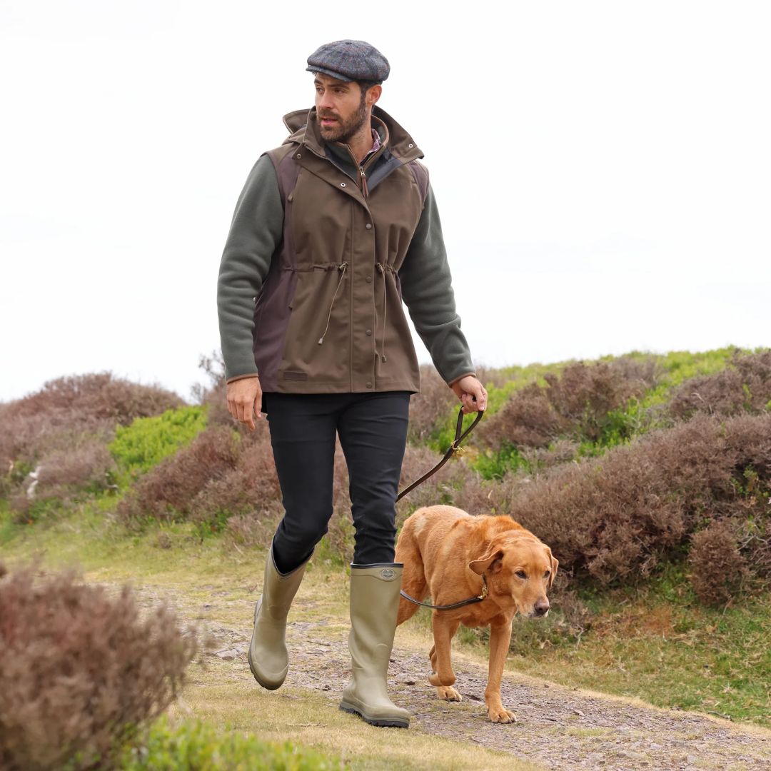 Man walking a dog on a path in a natural setting
