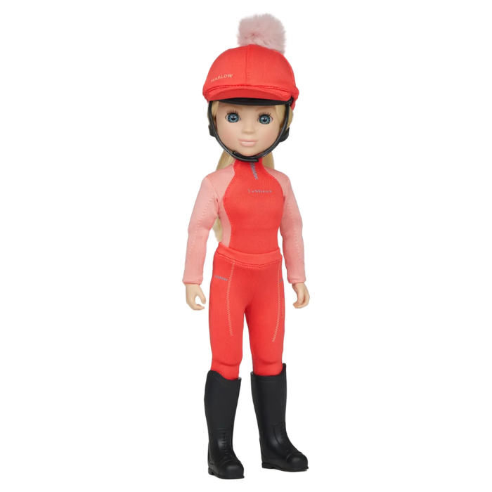 LeMieux Toy Rider Variant Harlow. 
A doll with blonde hair wearing a red riding helmet with a pink pom-pom, a pink and red one-piece riding suit, and black riding boots, standing against a plain white background.