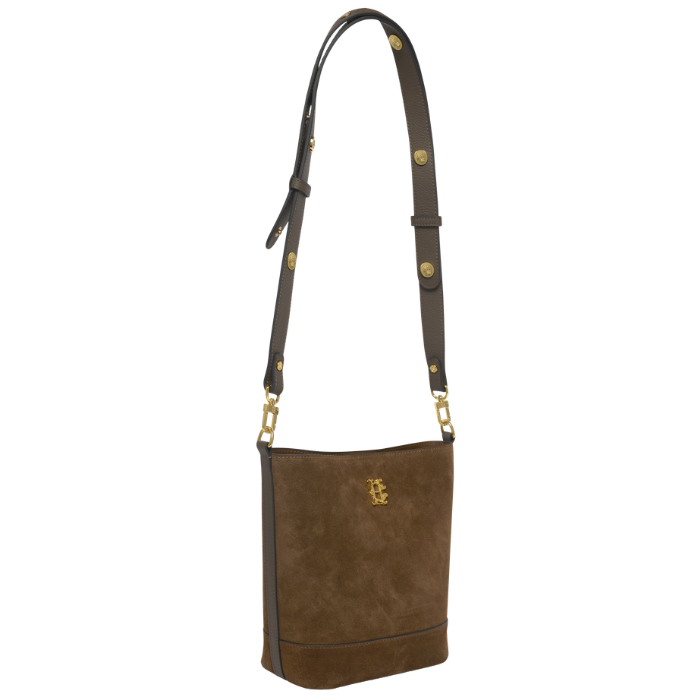 Holland Cooper Country Crossbody Bag Variant Colour Linchen Suede.
A brown suede shoulder bag with a matching adjustable shoulder strap, accented by gold-tone hardware and a small gold crest logo on the front.