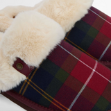 Close-up of tartan fabric with fluffy beige trim on a white background
