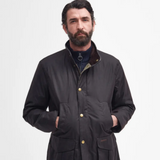 Man wearing a dark Barbour jacket with gold buttons on a white background