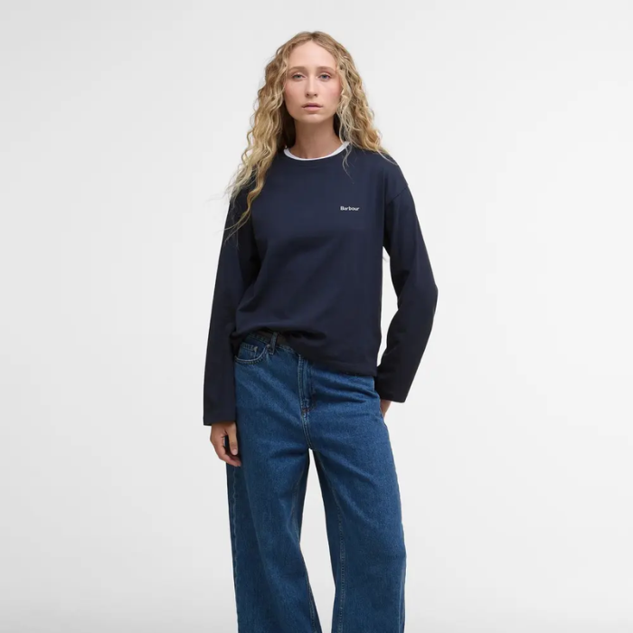 Person wearing a navy long-sleeve t-shirt and blue jeans on a white background