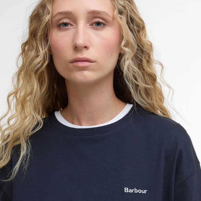 Person wearing a navy Barbour t-shirt against a white background