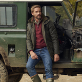 Man Perches Against Land Rover Wearing the Barbour Mens Bleaberry Wax Jacket in Fern