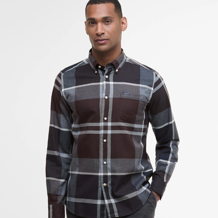 Man wearing a tartan shirt with a visible brand logo on a white background