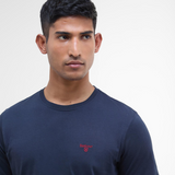 Man wearing a navy blue t-shirt with a red Barbour shield logo on a white background