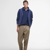 Man styles the Barbour Mens Holt Waffle Knitted Polo Shirt in Oceana with beige trousers and a sweater draped across his shoulders