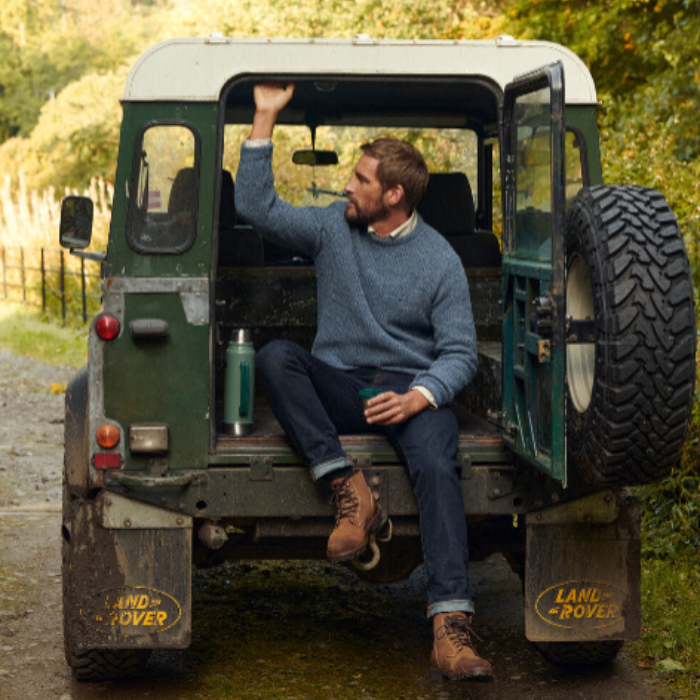 Man In Land Rover Wears Barbour Mens Horseford Crew Neck Jumper in River Blue | Eland Lodge