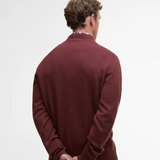 Man wearing a burgundy sweater on a light gray background