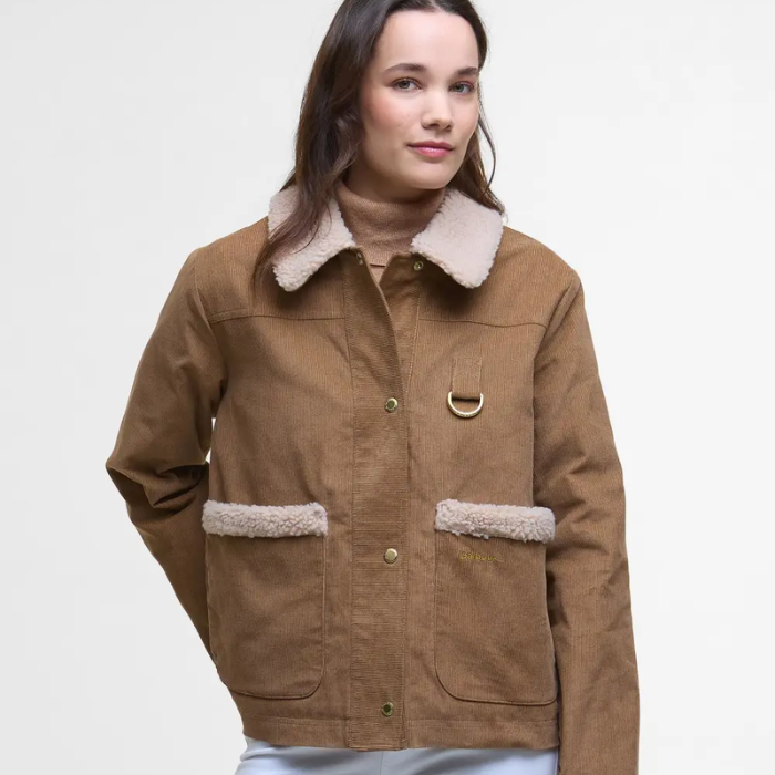 Woman wearing a brown Barbour jacket with shearling trim on a white background