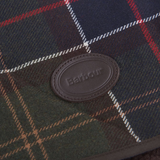 Close-up of a plaid fabric with a Barbour logo patch.