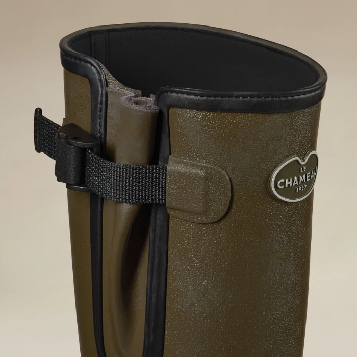 Le Chameau Ladies Vierzonord Neoprene Lined Wellies Variant Chameau Green Black Lining. Close-up of a tall olive green hunting boot with black trim and a black adjustable strap closure, featuring a silver oval Le Chameau logo on the side.
