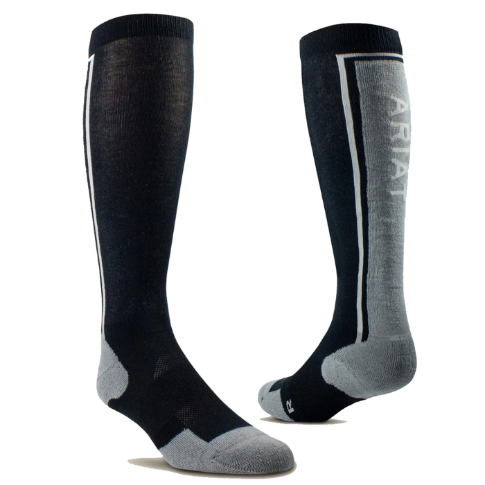 AriatTek Winter Slimline Socks Variant Black/Sleet. A pair of knee-high athletic socks shown on invisible forms against a white background. The socks are primarily black with gray accents on the toes, heels, and sole, and a vertical white stripe with the brand name 'ARIAT' printed in white on the side.