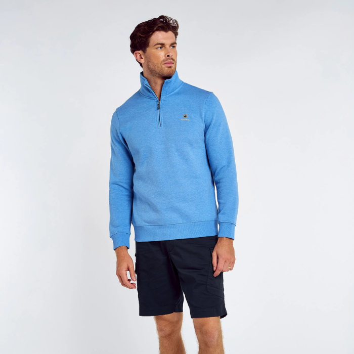 Man wearing a blue sweatshirt with a small logo on a white background