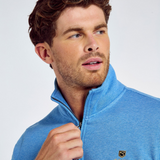 Man wearing a blue zip-up sweatshirt against a light grey background