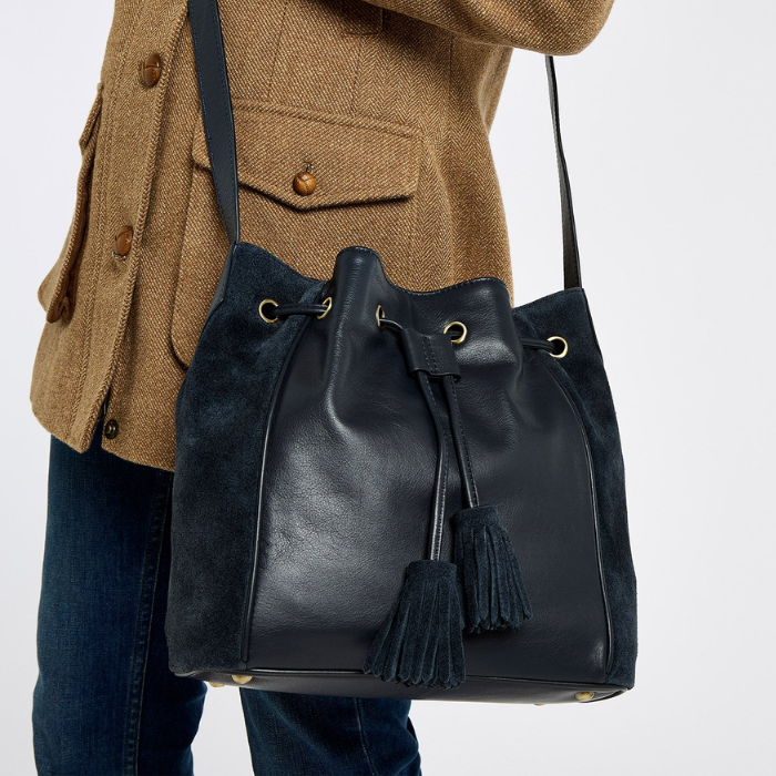 person wears a navy drawstring bag with tassels on a white background